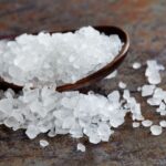 sea-salt-condiment-macro-view--natural-mineral-flavoring-food-preservative--saline-sodium-chloride-white-crystal-in-wooden-spoon--aged-background--shallow-depth-field-678871664-5ad66138642dca00365b9f2d